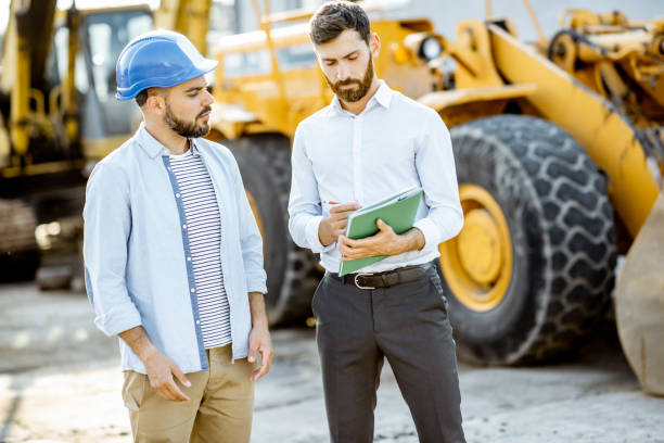istock Builder with a sales consultant at the shop with heavy machinery 1174262995