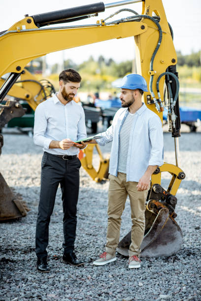 istock Builder with a sales consultant at the shop with heavy machinery 1174263049
