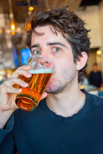 istock Young millennial looking at the camera drinking beer 1174263990