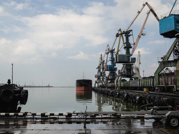 istock unloading of a tanker and loading into a freight train at a port of coal using powerful and large port cranes. Overall plan 1174268886