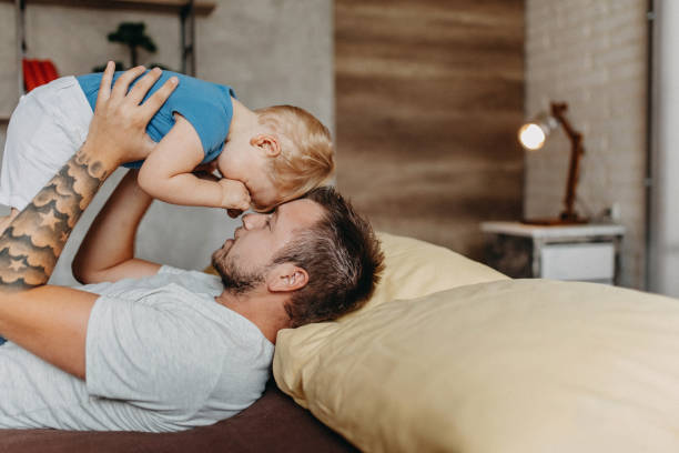 istock Happy father with his son playing at home on the bed 1174272821