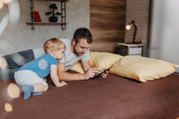 istock Father playing in bed with his little baby boy 1174273865
