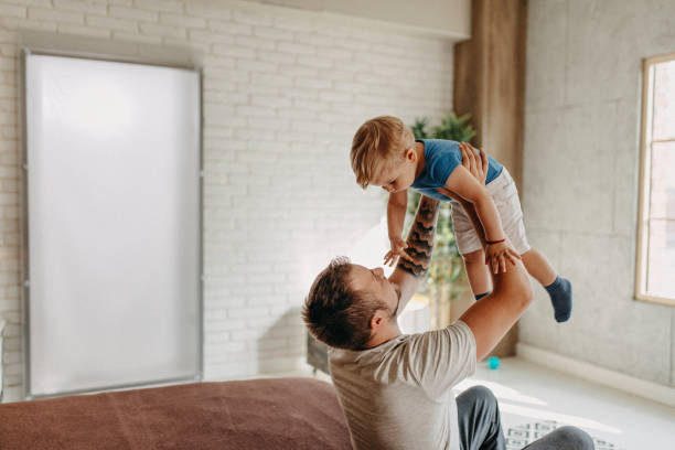istock Happy father with his son playing at home on the bed 1174274798