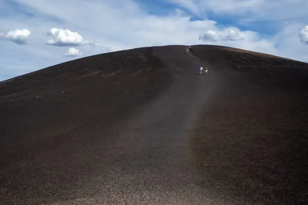 Hikers walk down from the Inferno Cone at Craters of the Moon National Monument