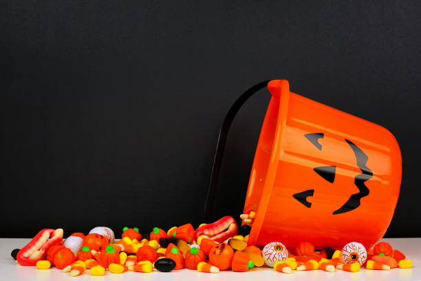 istock Halloween Jack o Lantern bucket with spilling candy with a black background 1174282310