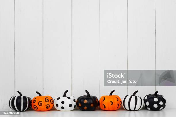Patterned Halloween Pumpkins In A Row Against A White Wood Background Stock Photo - Download Image Now