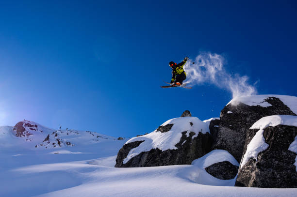esquiador que salta no pó fresco - skiing winter sport powder snow athlete - fotografias e filmes do acervo