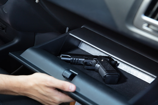 Driver Taking Handgun From Glovebox Compartment Inside Car