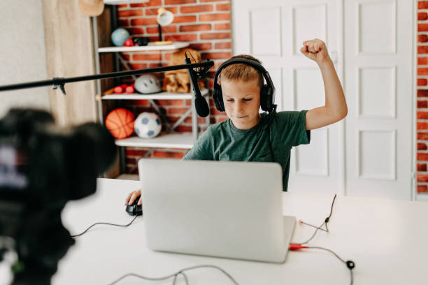 istock Boy in headphones playing video game on laptop 1174295751