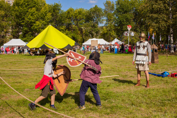Duel of warrior boys with shields and spears at a city holiday. stock photo