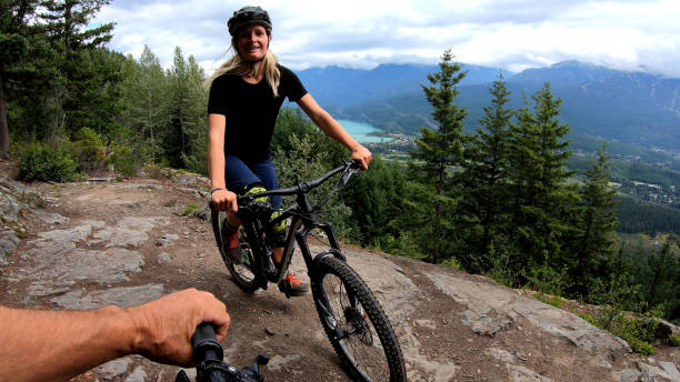 istock Female mountain biker rides on path through forest 1174298734
