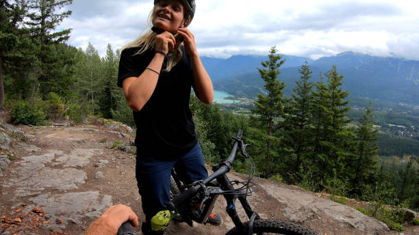 istock Female mountain biker removes helmet and looks out 1174299575