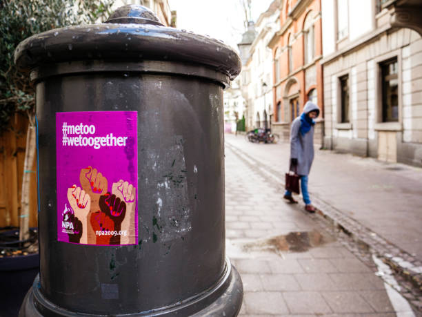 Woman with Metoo wetoogether campaign poster Paris, France - Dec 15, 2017: Single sad woman walking on French street with Metoo wetoogether campaign poster on the steel pillar me too social movement stock pictures, royalty-free photos & images