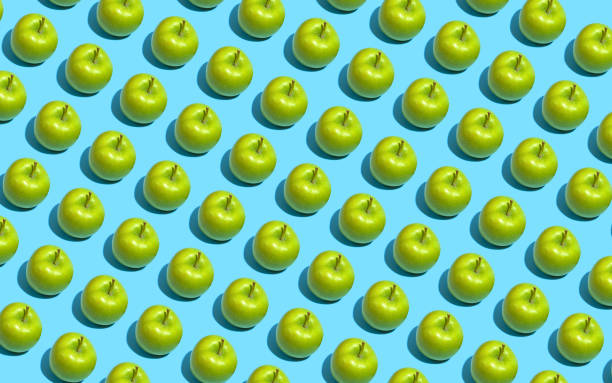 istock Fruit pattern of fresh green apples on blue background. Top view. Summer concept. Collage 1174302007