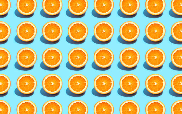 istock Fruit pattern of fresh orange slices on blue background. Top view. Summer concept. Collage 1174302046