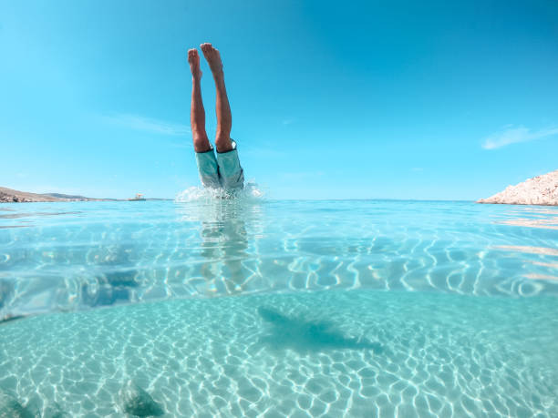 hombre saltando al mar - salto desde acantilado fotografías e imágenes de stock