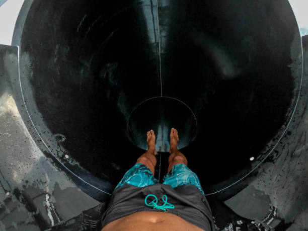 a smiling young woman is sliding on a water slide.