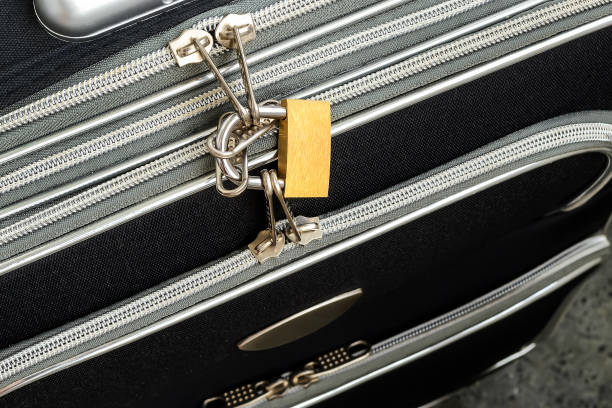 istock Zippers locked with a padlock on a black travel suitcase. Protect the baggage from theft during the trip. Luggage theft prevention. Security of the suitcase in travel. 1174303382