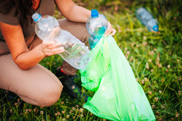 istock Female volunteer picks up trash in park 1174306078