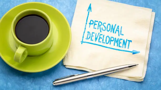 personal development -handwriting on napkin with a cup of coffee