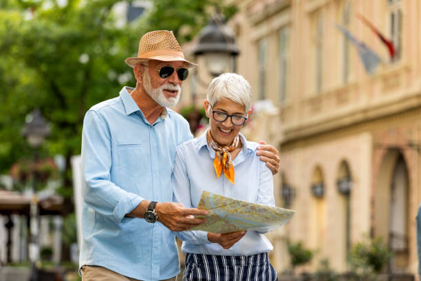 istock Active Senior Tourists are Walking Through the City Streets with Map 1174307283