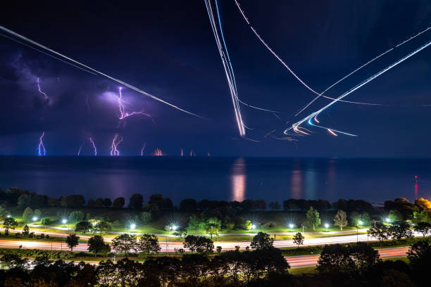 A beautiful lightning and plane long exposure panoramic compilation photograph along Lake Shore Drive and the lakefront of Lake Michigan in Chicago with water reflections and light trails. stock photo