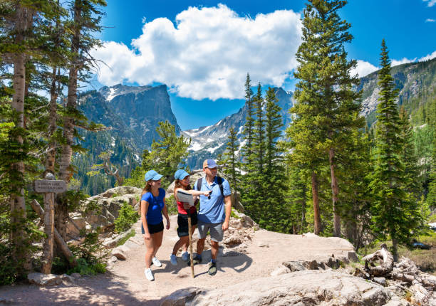 Smiling happy family relaxing on the hiking trail. Smiling happy family relaxing on the hiking trail. Smiling people enjoying time together in the mountains on  Emerald trail. Estes Park, Rocky Mountains National Park, Colorado, USA. estes park stock pictures, royalty-free photos & images