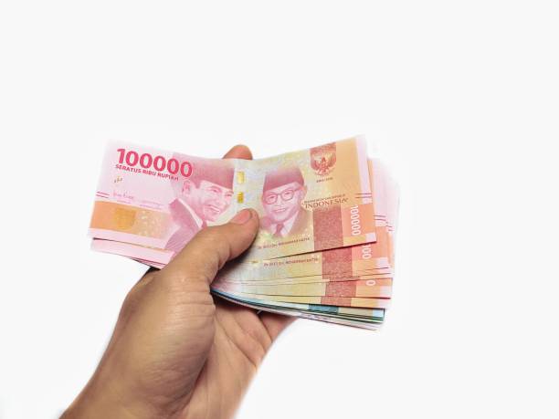 istock Hand showing Indonesian banknote on white background 1174318974