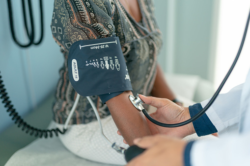 A la mujer adulta madura se le revisa la presión arterial photo