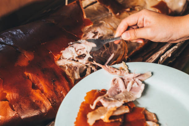 consegna un pezzo del popolare e delizioso maiale arrosto o "lechon baboy" usando la forchetta. - pig roast foto e immagini stock