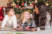 zwei-junge-schwestern-lesen-im-wohnzimmer-am-weihnachtsbaum-mit-ihrer-mutter.jpg?b=1&s=170x170&k=20&c=b8i1F5B6_CxYQSWrXg1sC1eLT-AndqRxzdb8Uk4B9uA=