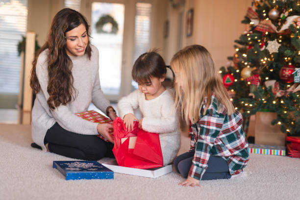 istock Two young sisters unwrapping a Christmas present together 1174331193