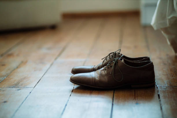 Get out of bed and get the day started Shot of two formal men’s shoes on the floor of a bedroom pair of shoes stock pictures, royalty-free photos & images