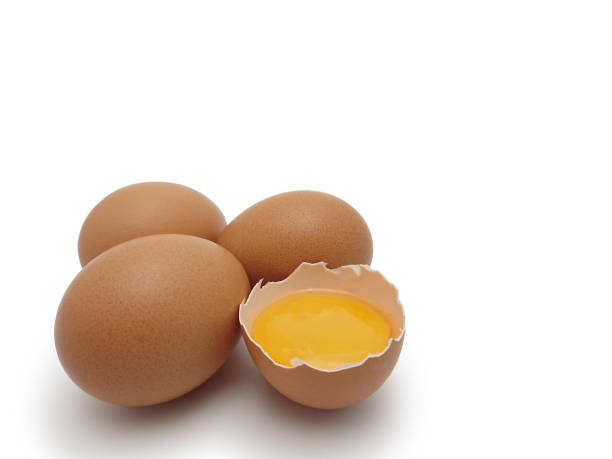 istock Whole eggs with cracked egg showing yolk isolated on white background with Clipping path 1174347545