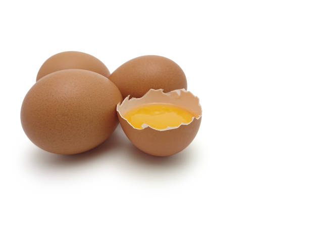istock Whole eggs with cracked egg showing yolk isolated on white background with Clipping path 1174347552