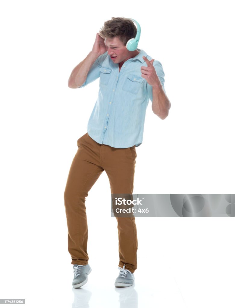 One Person Full Length Of 2029 Years Old Handsome People Short Hair  Caucasian Male Young Men In Front Of White Background Wearing Button Down  Shirt Pants Who Is Listening And Using Headphones