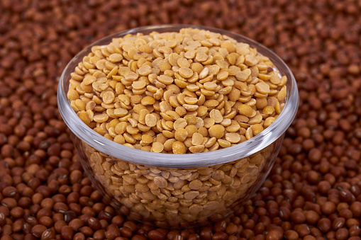 Bowl containing Split Pigeon Pea (Cajanus cajan) or Congo Pea against whole pigeon pea background