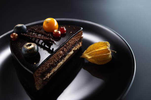 istock Chocolate cake with decoration and fruits on black background 1174351530