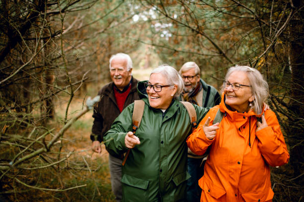 Seniors hiking through the foerst Close up of a group of seniors hiking through the forest raincoat photos stock pictures, royalty-free photos & images