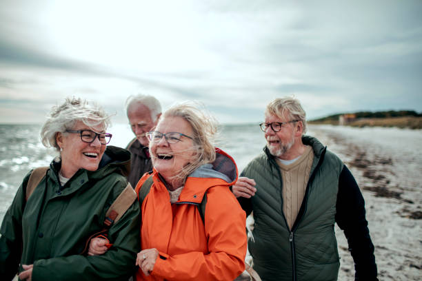 anziani che camminano sulla spiaggia - bag senior adult outdoors friendship foto e immagini stock