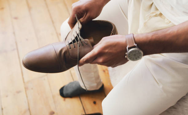 Cropped shot of an unrecognizable man putting on a watch in preparation for his wedding