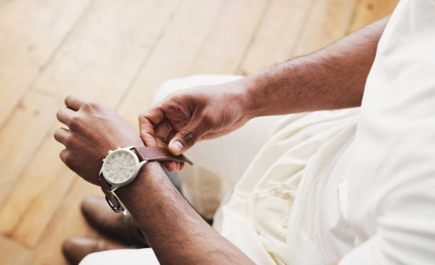 Use your time wisely Shot of an unrecognizable man putting on a watch in preparation for his wedding arm span stock pictures, royalty-free photos & images