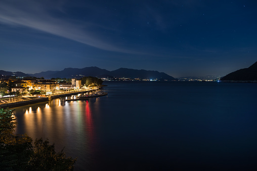 Lake Maggiore at dusk, Maccagno important Italian tourist destination near the border with Switzerland. In the background is visible both a stretch of the Lombardy coast (between Germignaga and Laveno) and of Piedmont with the city of Stresa. Lake also called Verbano