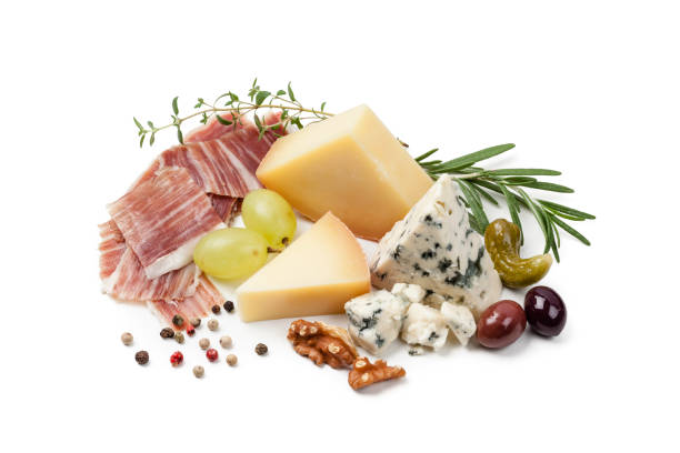 Iberico ham slices and various cheeses shot on white background. The composition is placed directly on the white background and includes olives, grapes, herbs and some nuts. Some peppercorns complete the composition. High key DSRL studio photo taken with Canon EOS 5D Mk II and Canon EF 100mm f/2.8L Macro IS USM.