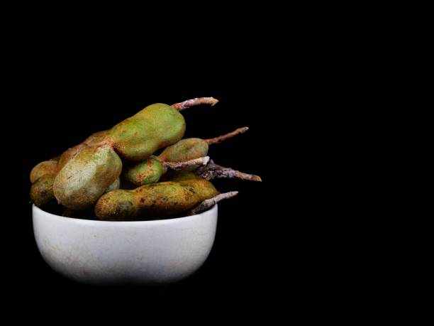 tamarind​ in​ ceramic​ cup​ on​ black​ background​