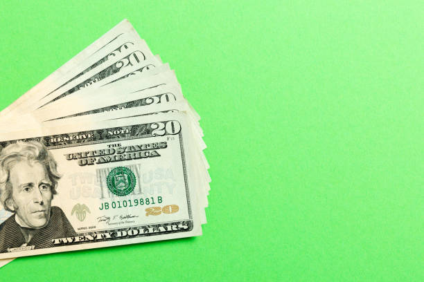 istock Stack of 20 dollar banknotes on colorful background. Top view of financial concept with empty space for your design 1174373777