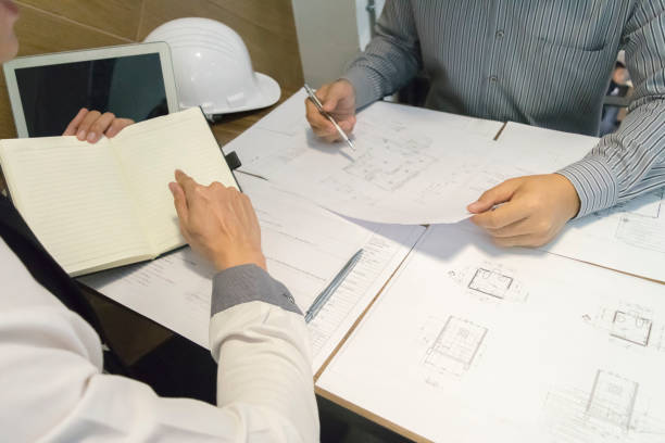 istock Midsection Of Engineers Working On Blueprint At Office 1174377981