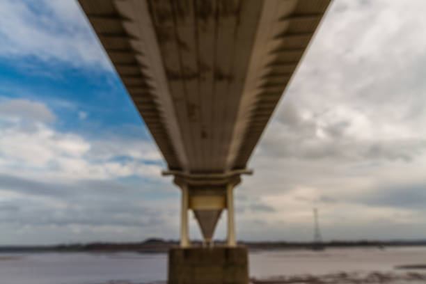 Beneath the Old Severn Crossing suspension bridge. Underside of bridge, landscape.