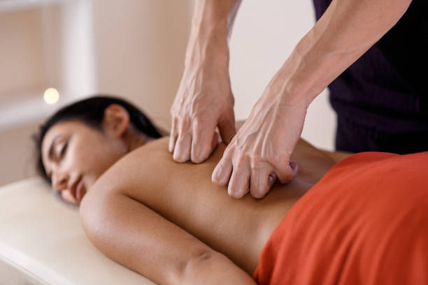 istock A young woman gets a massage procedure. Masseur makes back massage 1174386899