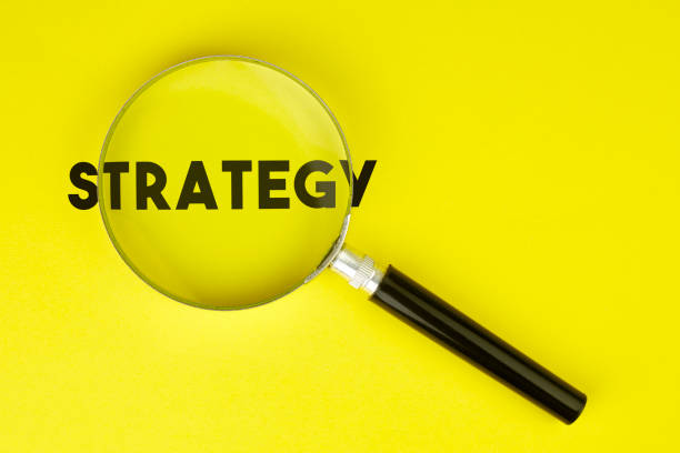 istock Magnifier And Strategy Text On Yellow Background Stock Photo 1174391746